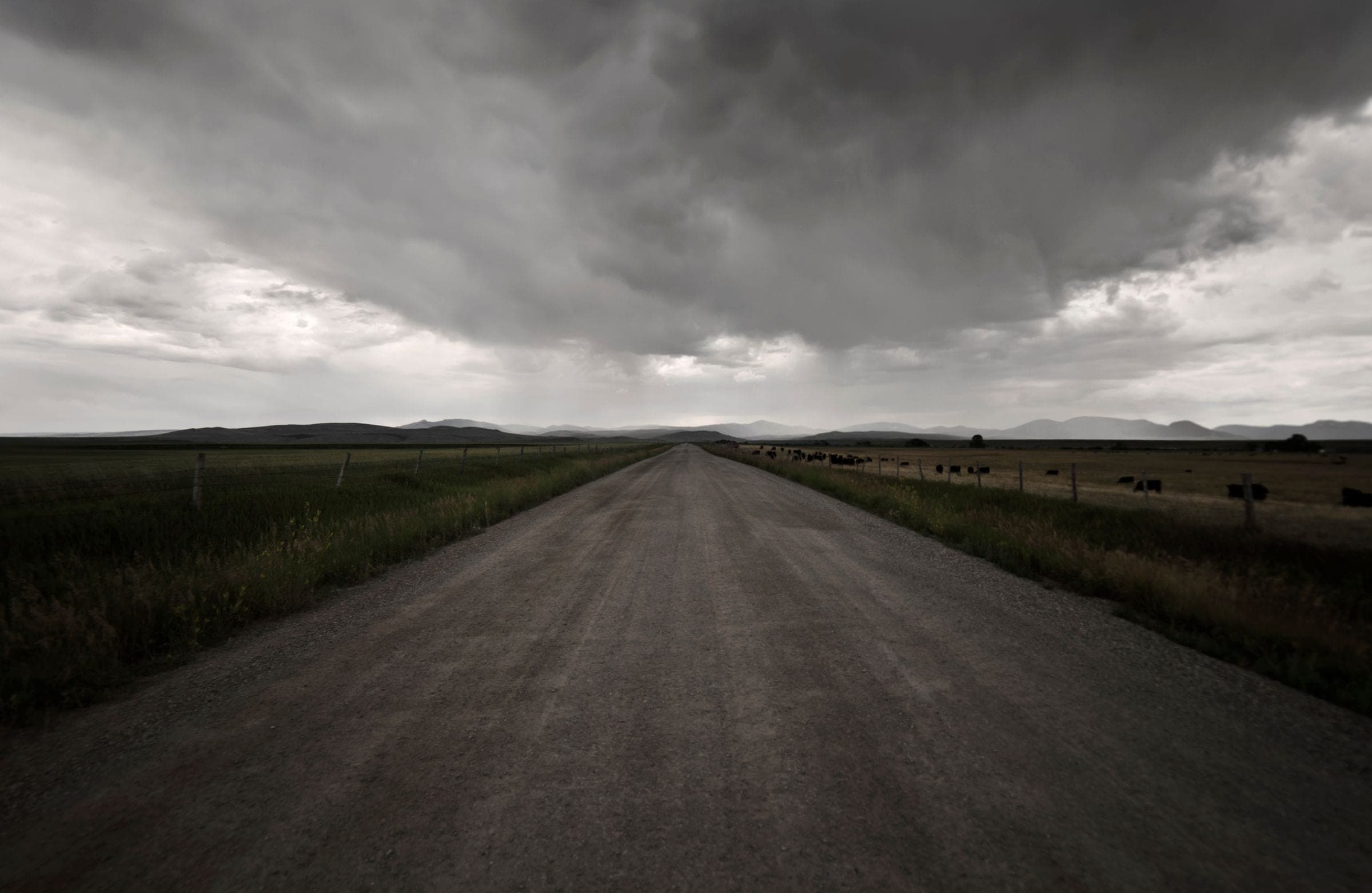 Windshield replacement for Hardin, MT drivers: long empty road across the plains under a stormy sky