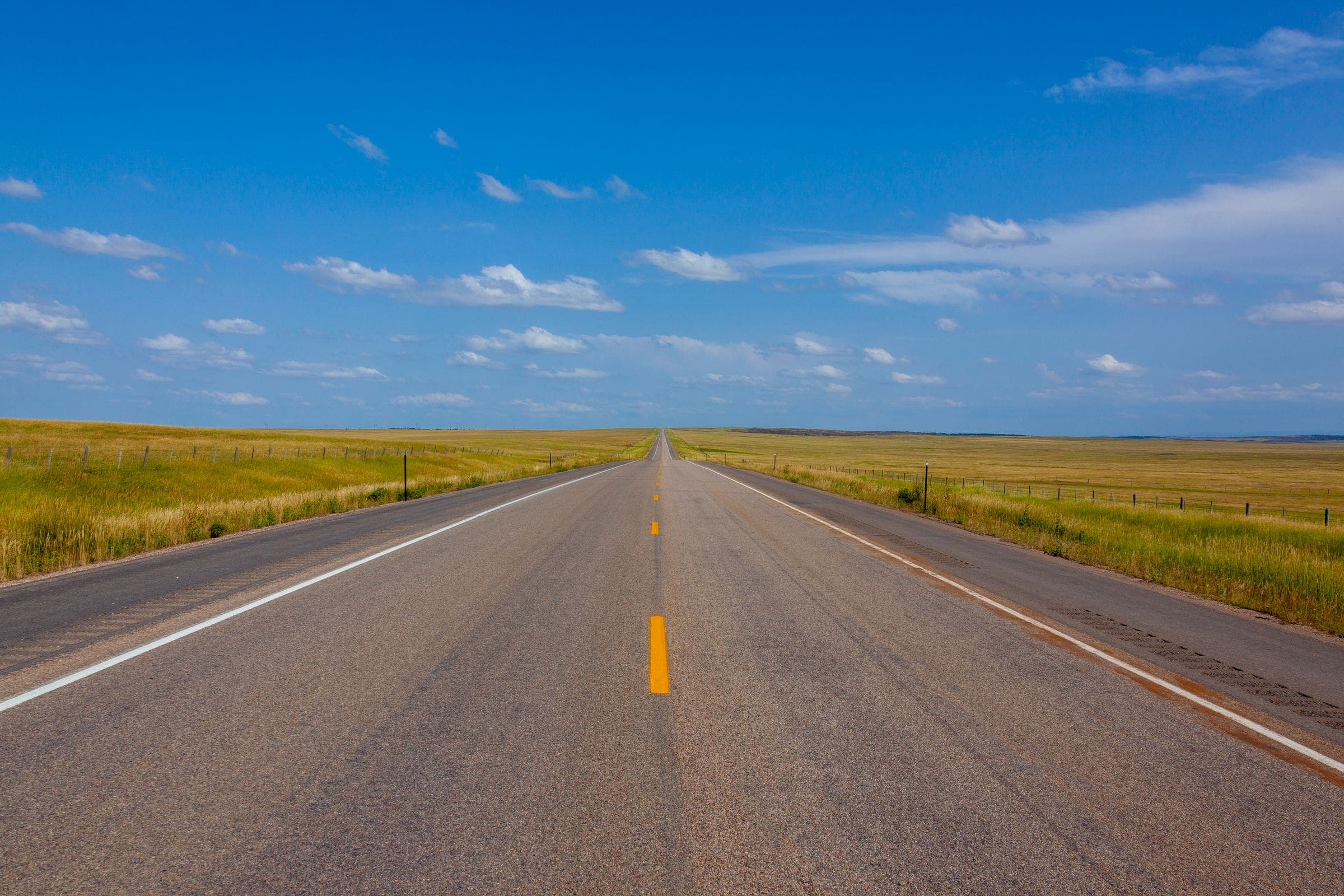 Windshield replacement for Laurel, MT drivers: straight two-lane road across open Montana prairie
