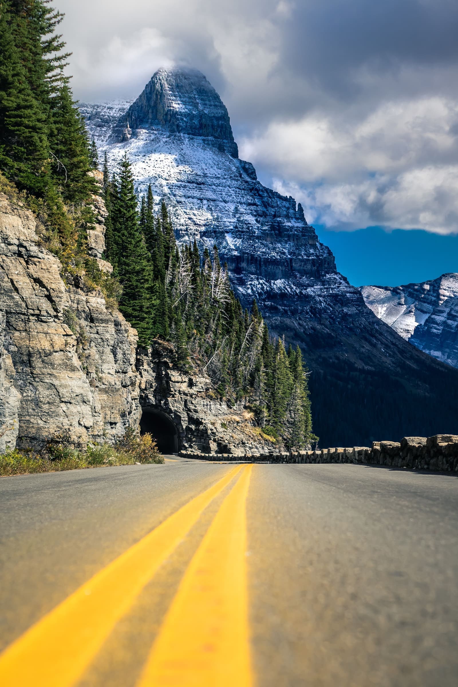 Windshield replacement for Red Lodge, MT drivers: mountain road climbing past cliffs toward snowy peaks