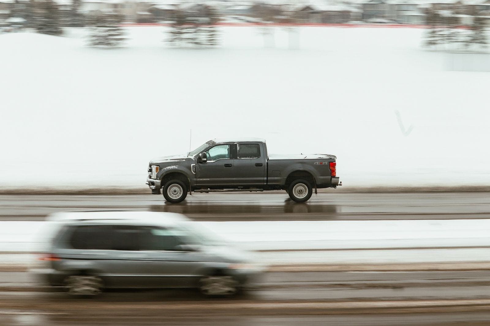 Pickup truck driving a slushy winter highway