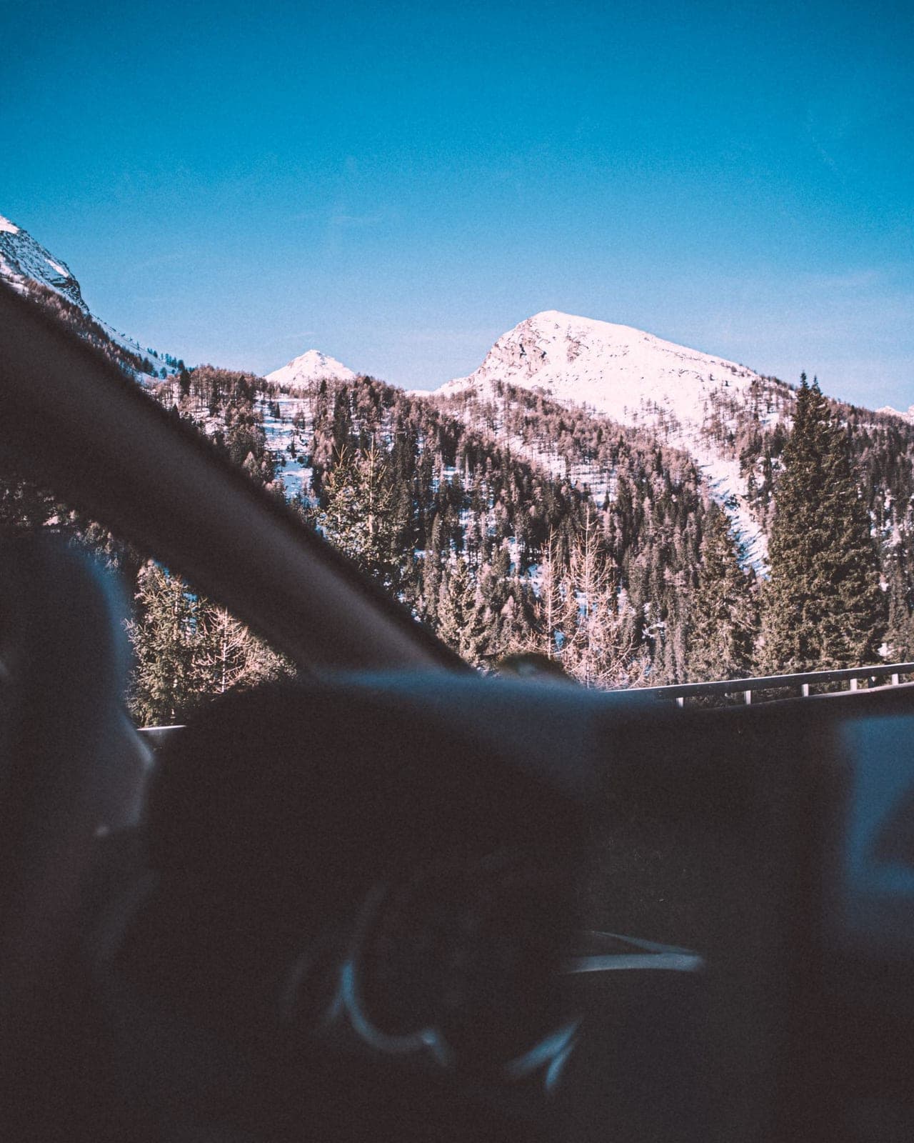 Snowy peak framed by a car windshield and dashboard