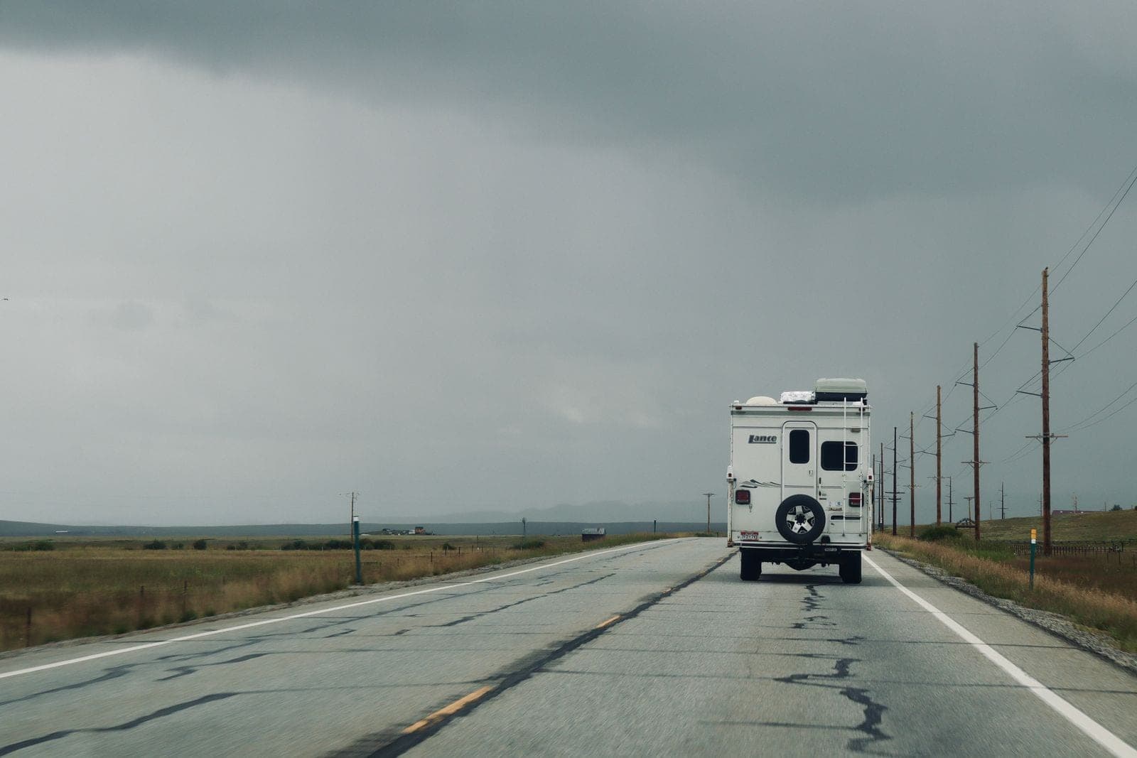 Motorhome driving away down a wet rural highway