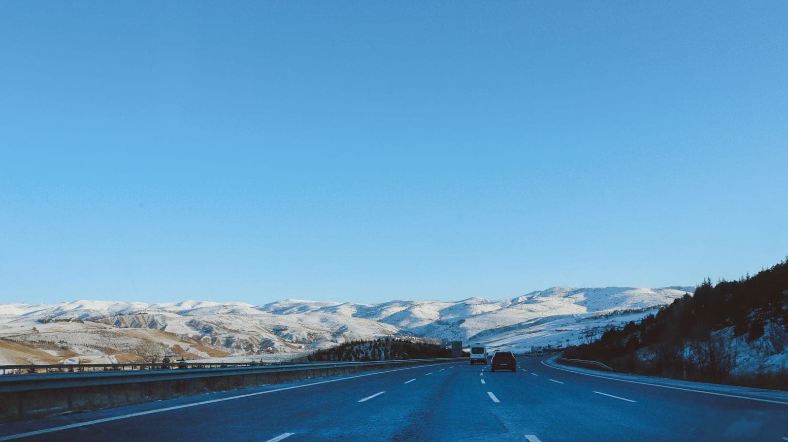 Highway leading toward snow-covered hills