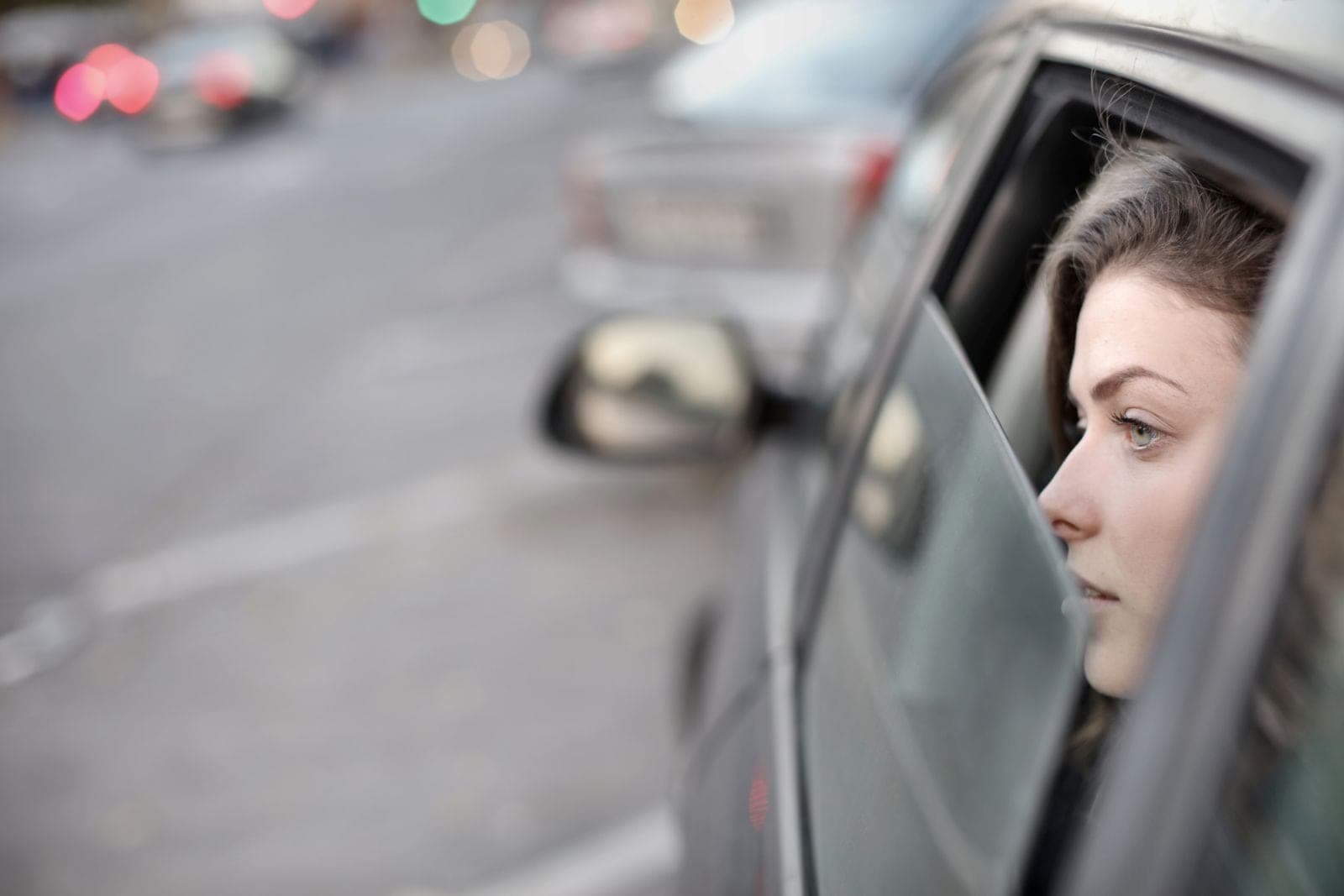 Passenger looking out of an open car window
