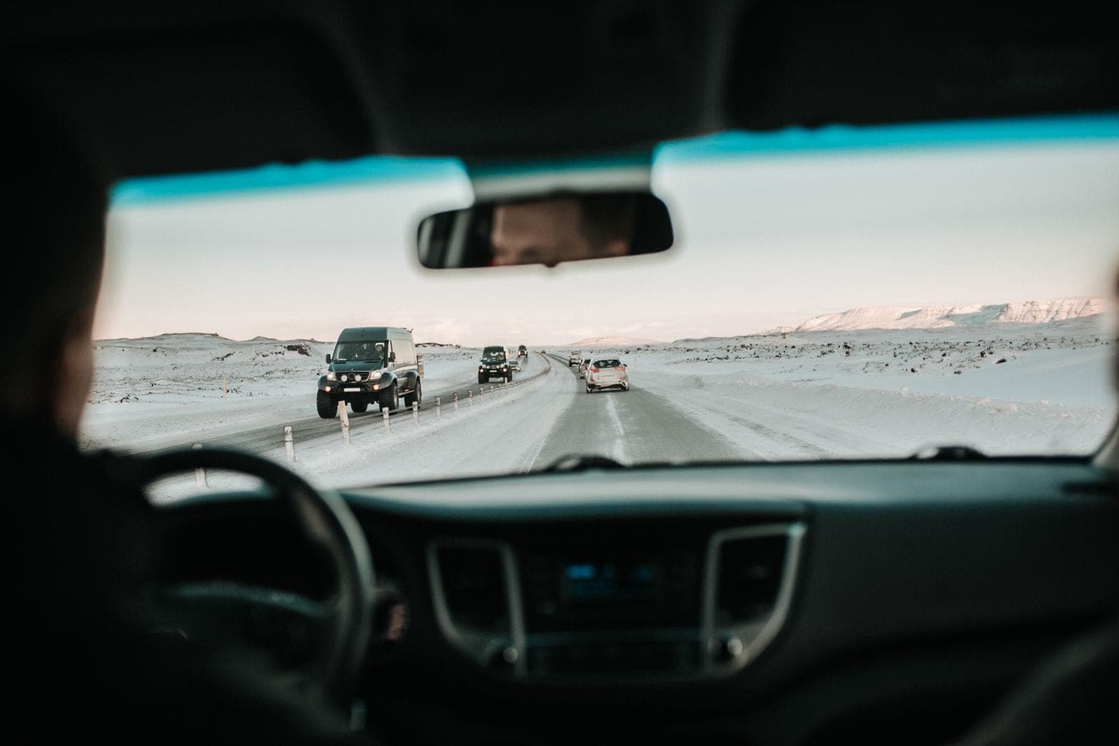 Snowy highway traffic seen through the windshield