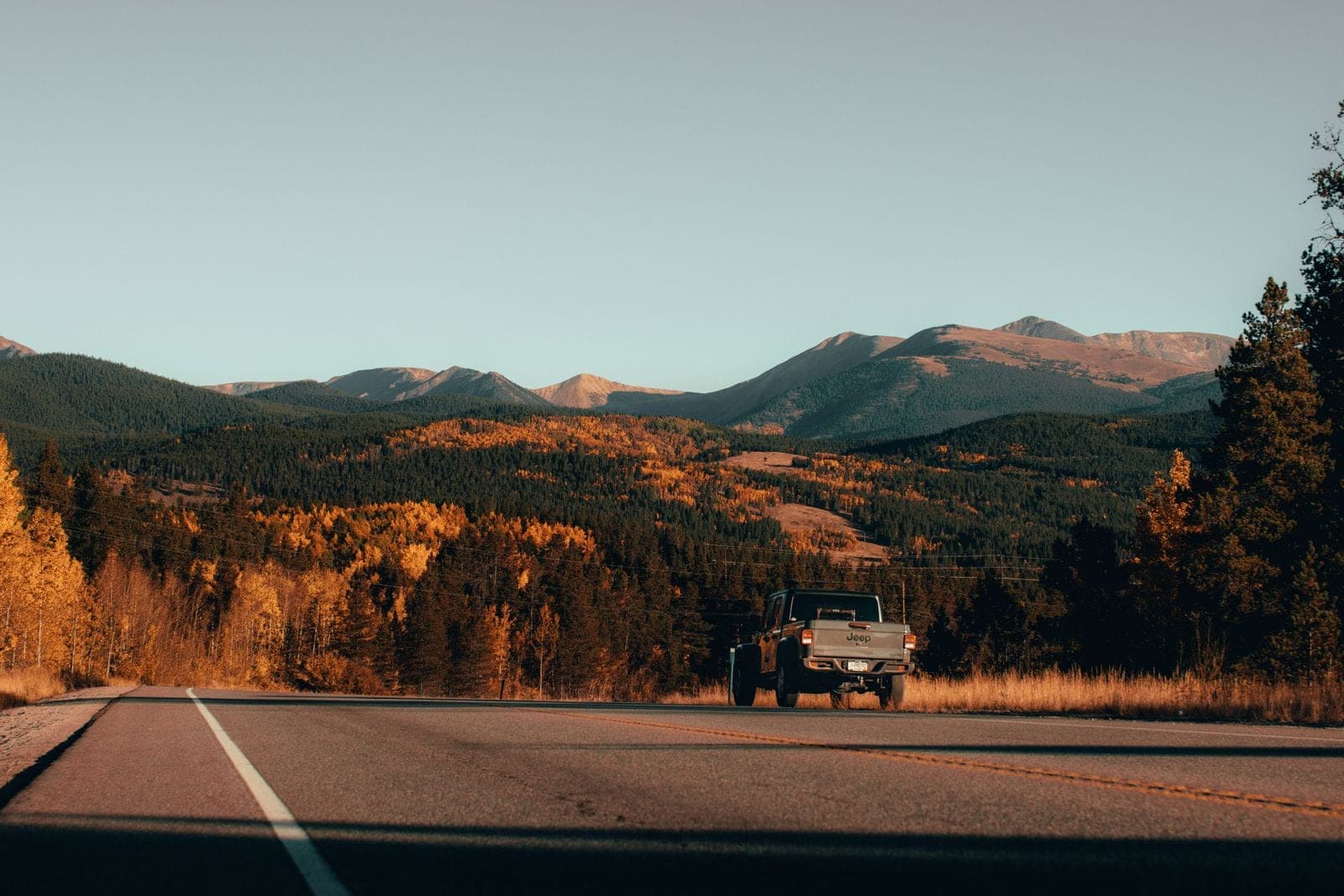 Pickup on a mountain road in autumn light